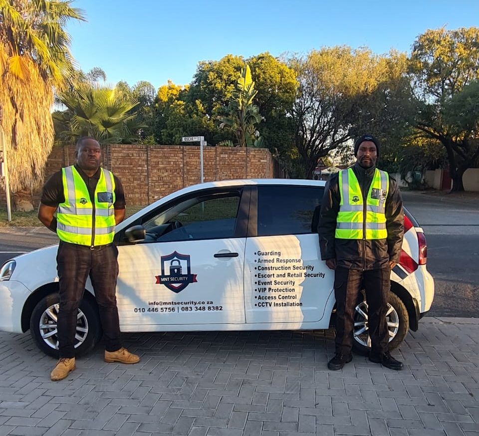 Two MNT Security officers beside a branded response vehicle